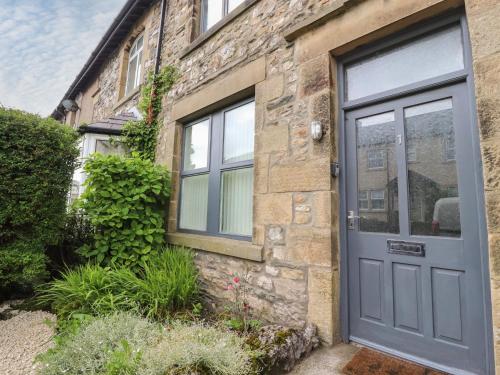 a stone house with a blue door at 1 Lytham Terrace in Carnforth