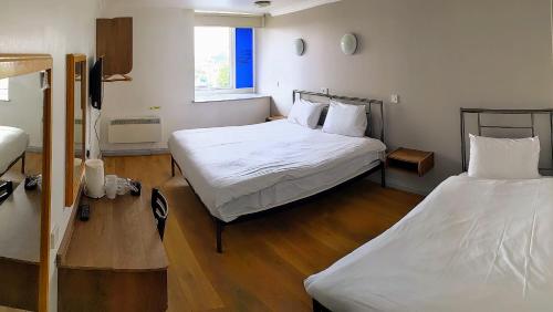 a room with two beds and a window at 247Hotel in Oldham