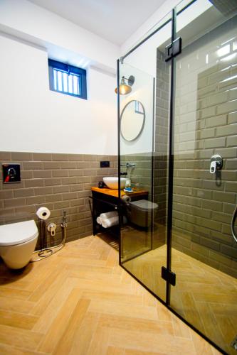 a bathroom with a toilet and a glass shower at Borjomi Bridge Hotel in Borjomi