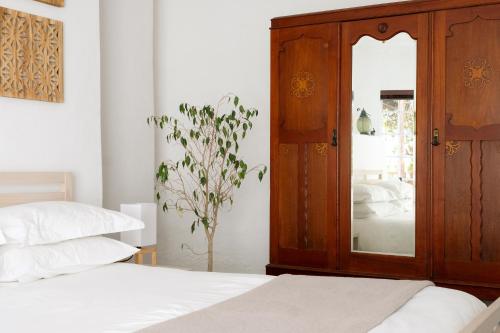a bedroom with a wooden cabinet and a mirror at Kogman & Keisie Guest Farm in Montagu