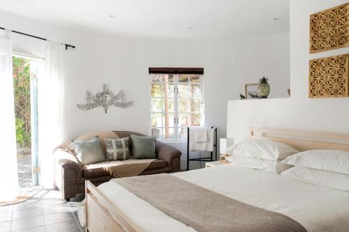 a white bedroom with a bed and a couch at Kogman & Keisie Guest Farm in Montagu