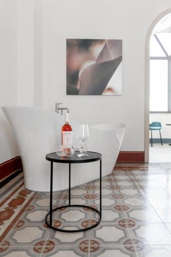 a table with a bottle and glasses on it in a room at PALAZZO FRANGIPANE in Salve