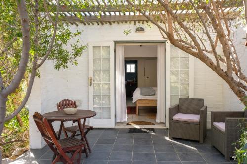 a patio with a table and chairs and a bed at Kogman & Keisie Guest Farm in Montagu
