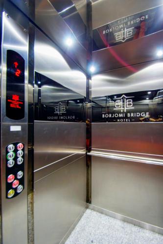 a metal elevator in a room with a wall at Borjomi Bridge Hotel in Borjomi