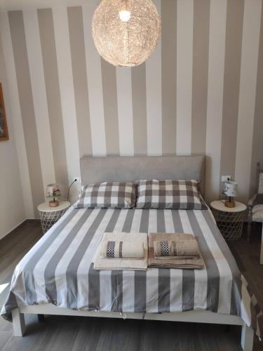 Un dormitorio con una cama con paredes a rayas y una lámpara de araña. en Rossetto e cocciolato - Stanza indipendente con bagno privato a Pesaro, en Pesaro