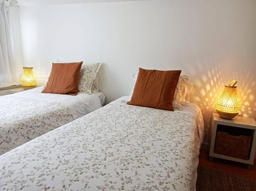 two beds in a room with two lamps at City Center House in Ponta Delgada