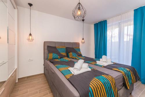 een slaapkamer met een groot bed en handdoeken bij Apartment Jakov with pool in Zadar