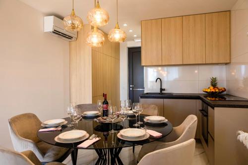 a dining room with a table and chairs and a kitchen at Villa Nina - Apartments with pool near the sea in Rabac