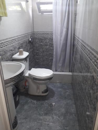 a bathroom with a toilet and a sink at Nunu's Guesthouse in Tskaltubo