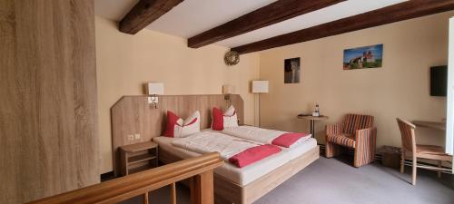 a bedroom with a bed with red pillows at Hotel Zum Schloss in Quedlinburg