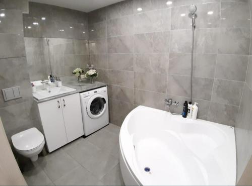 een badkamer met een wastafel en een wasmachine bij Apartment on Potanina 16 in Öskemen