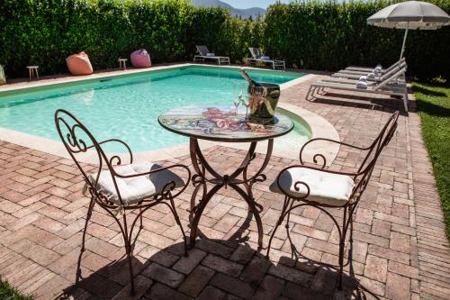 a table and two chairs next to a swimming pool at Domus Angeli in Assisi