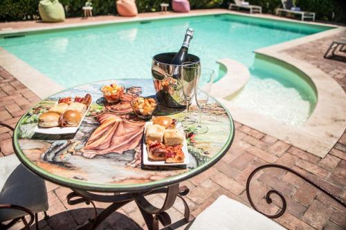 a table with food and a bottle of wine next to a pool at Domus Angeli in Assisi