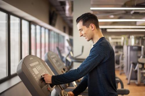 a man exercising on a treadmill in a gym at Hotel Bażantowo Sport in Katowice