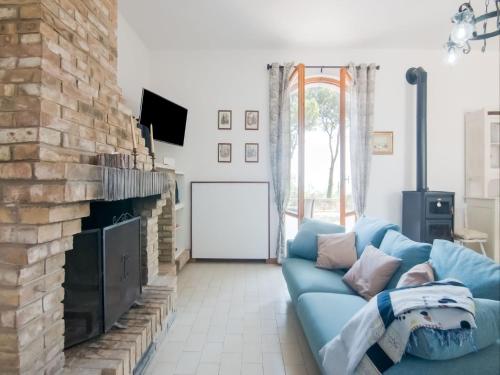 uma sala de estar com um sofá azul e uma lareira em Belvilla by OYO Brezza dal Mare em Pesaro