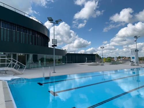 uma grande piscina em frente a um edifício em Camping le Rochat Belle Isle em Châteauroux