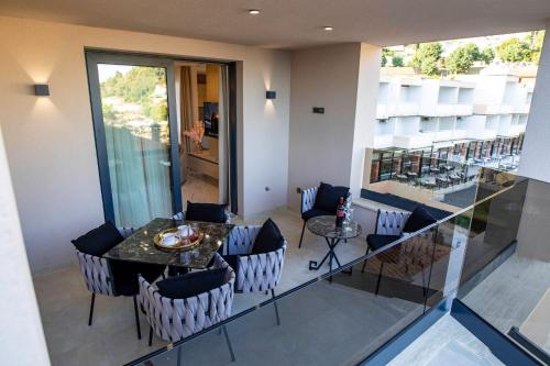 a dining room with a table and chairs on a balcony at Villa Nina - Apartments with pool near the sea in Rabac