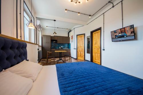 ein Schlafzimmer mit einem Bett mit einer blauen Decke in der Unterkunft Loft Design Apartments near Maidan in Kiew