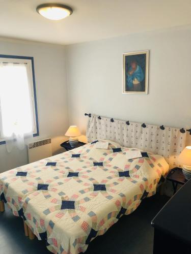 une chambre avec un lit avec une couette dessus dans l'établissement CONCORDE - St Colomban, Jardin, Vue mer - T7, à Carnac