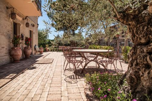 a patio with a table and chairs and a tree at Domus Angeli in Assisi