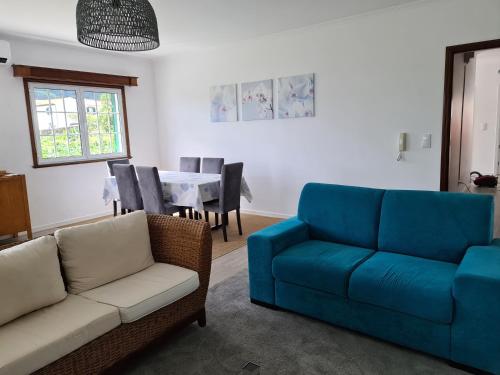 a living room with a blue couch and a table at Casa da Adega in Ribeira Chã