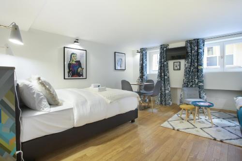 une chambre avec un lit, une table et des chaises dans l'établissement Résidence Le Marais by Studio prestige, à Paris