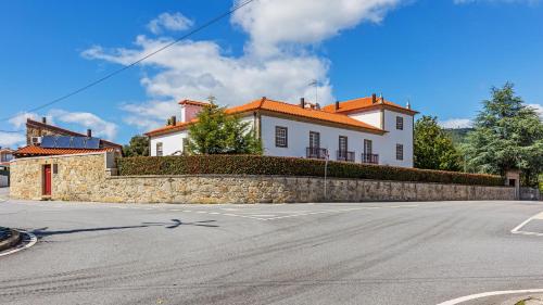 a large white house with a stone wall at Hotel Rural Quinta de Sao Sebastiao in Barroselas