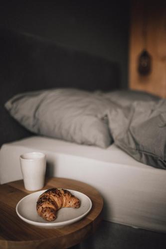 un piatto di cibo su un tavolo accanto a un letto di Pitzner - Winery & Suites a Cornedo all'Isarco