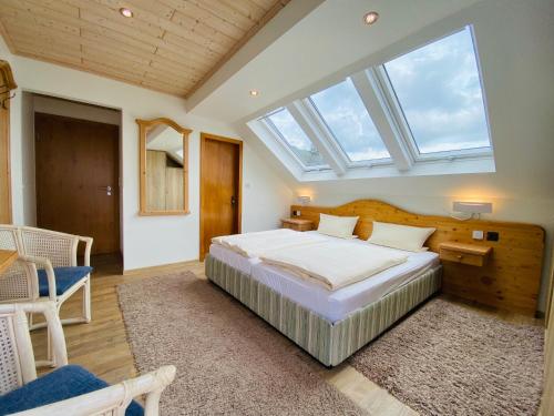 a bedroom with a large bed and a skylight at Landhotel Edersee in Waldeck