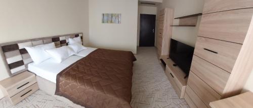a small bedroom with a bed and a television at Hotel Dream in Stara Zagora