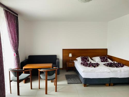 a hotel room with a bed and a table and chairs at Pod Orłem in Kudowa-Zdrój