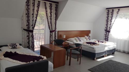 a hotel room with two beds and a table and a chair at Pod Orłem in Kudowa-Zdrój
