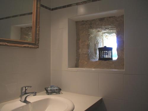 une salle de bain blanche avec un lavabo et un miroir dans l'établissement Chambres d'Hôtes Le Val de la Garenne, à Senouillac