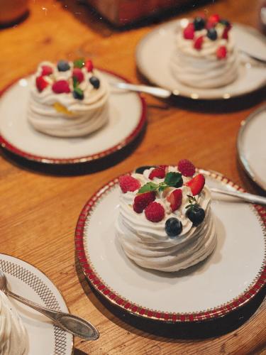 a table with three cakes on plates with berries on them at Muhu Tõnise Talu in Liiva