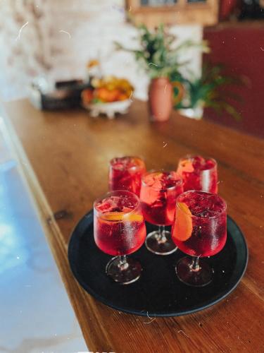 a group of four cocktails on a black plate on a table at Muhu Tõnise Talu in Liiva