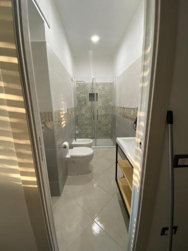 a white bathroom with a toilet and a sink at La casa del Maestro in Pisciotta