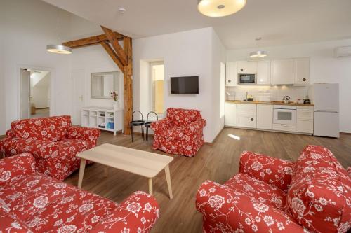 a living room with red couches and a table at Unesco Prague Apartments in Prague