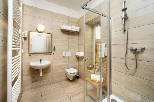 a bathroom with a shower and a toilet and a sink at Unesco Prague Apartments in Prague