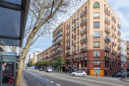 una calle de la ciudad con edificios altos y una calle con coches en Habitaciónes Luminosas y acogedoras, en Madrid