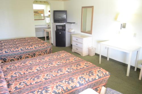 a hotel room with two beds and a television at Scottish Inn and Suites NRG Park/Texas Medical Center - Houston in Houston