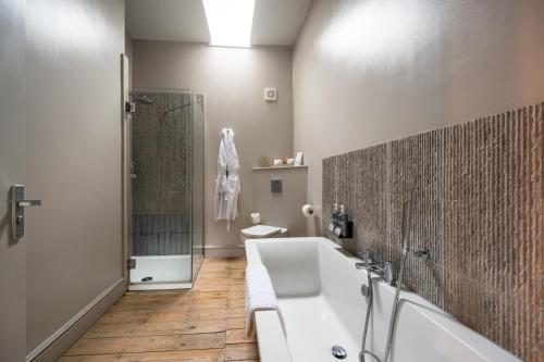 a bathroom with a tub and a shower and a sink at No33 HUNSTANTON BOUTIQUE ROOMS in Hunstanton