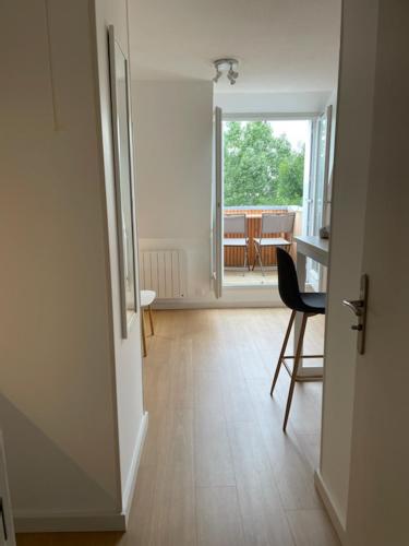 une pièce avec une table, une chaise et une fenêtre dans l'établissement Joli studio vue mer et campagne, à Blonville-sur-Mer