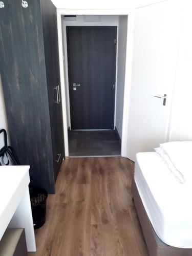 a room with a hallway with a bed and a door at No Stress Panzió-Pizzéria-Sporttábor in Harkány