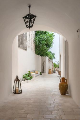 an archway in a white building with a vase on the floor at PALAZZO FRANGIPANE in Salve