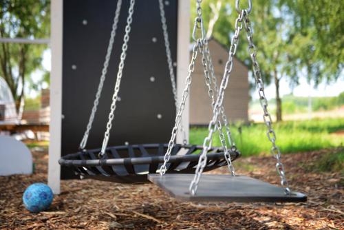 a swing in a yard with a blue ball at JURA GLAMP luksusowe całoroczne domki na wyłączność KOPUŁY IGLOO taras ogród in Wola Kalinowska