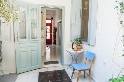 a hallway with a blue door and a table and chairs at Athenian Yard Near Acropolis in Athens