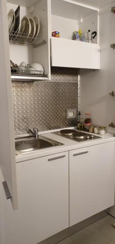 a kitchen with white cabinets and a sink at La casa di Balto, un nido per 2 in Castelnuovo Magra