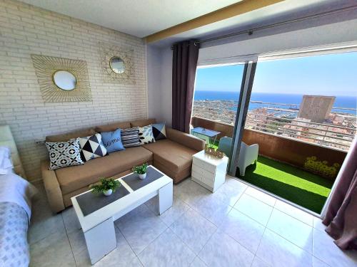 a living room with a couch and a large window at Mirador 22 in Alicante