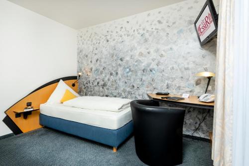 a hotel room with a bed and a desk at Hotel Restaurant Esser in Wegberg