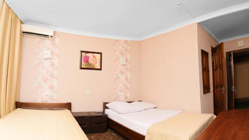 a bedroom with two beds and a table at Green City Hotel in Mykolaiv